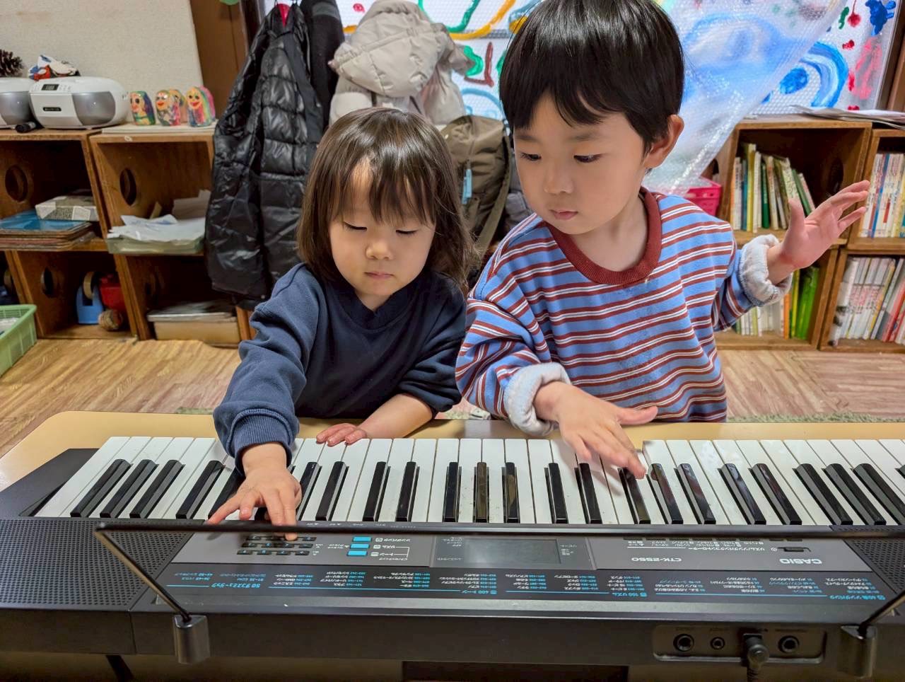 園児たちがピアノを一緒に弾いて楽しむ様子
