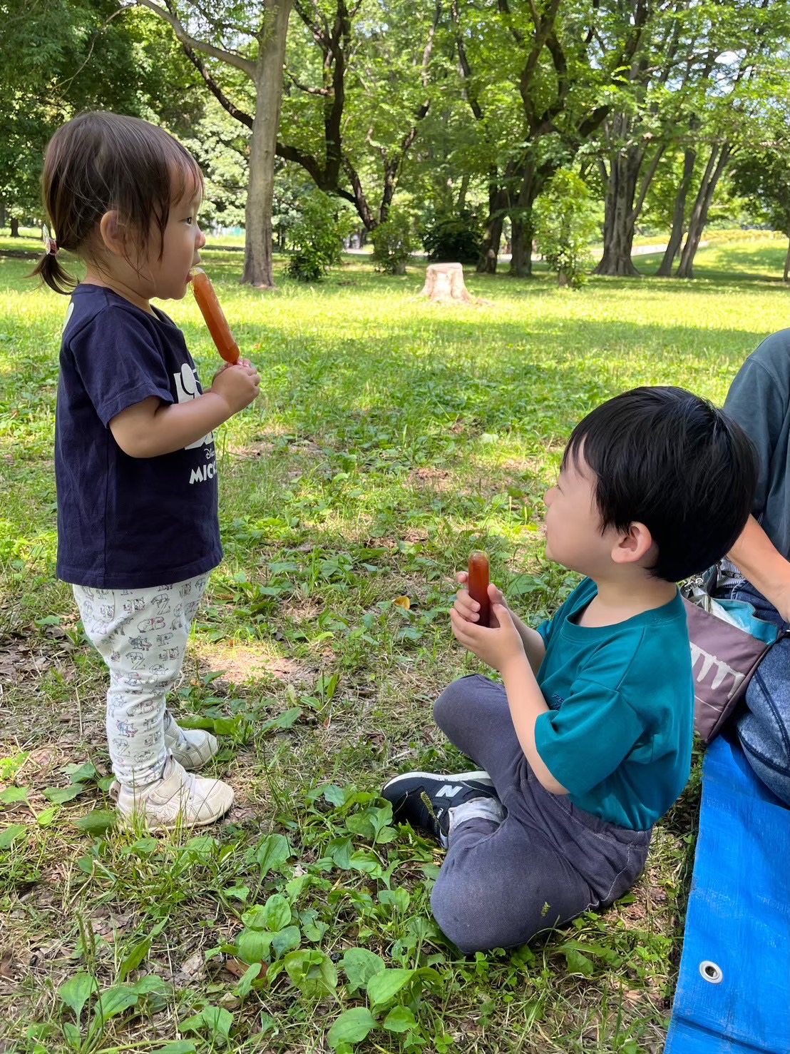 公園でみんなでおやつを食べる園児たち